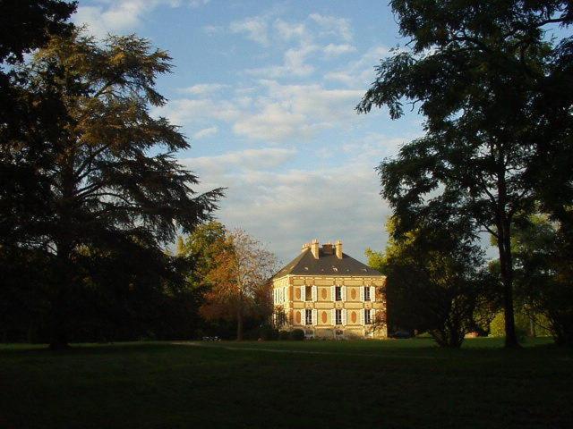 una casa grande en medio de un campo con árboles en Château des Bouffards, en Brinon-sur-Sauldre