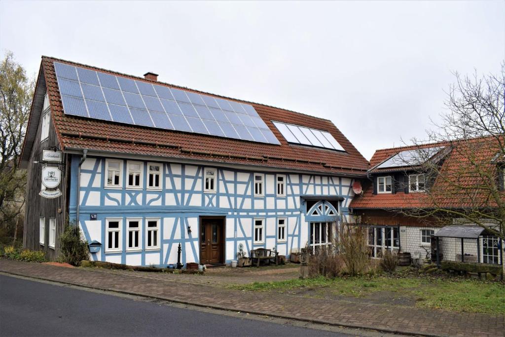 Birstein的住宿－Cäcilienhof，一座白色和蓝色的建筑,上面有太阳能电池板