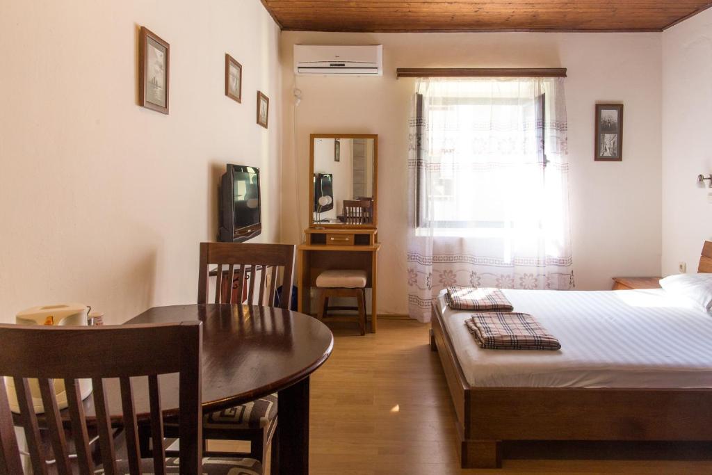 ein Schlafzimmer mit einem Bett und einem Tisch sowie ein Esszimmer in der Unterkunft Apartments Kole in Rafailovici