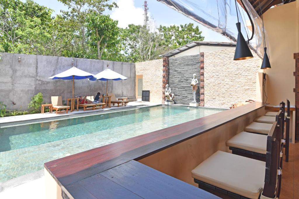 basen z leżakami i parasolami w obiekcie RedDoorz @ Uluwatu Bali w mieście Uluwatu