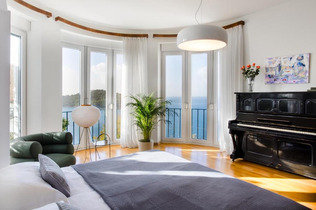 een slaapkamer met een bed en een piano bij Villa Paulina in Dubrovnik