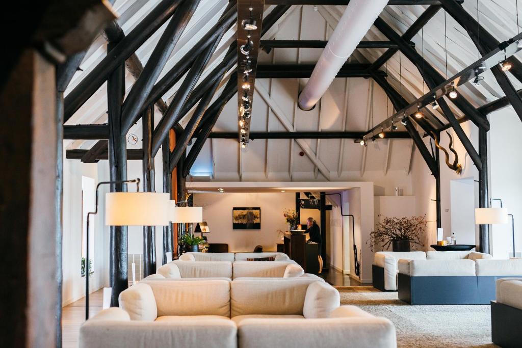 een woonkamer met witte banken in een gebouw bij Mooirivier in Dalfsen