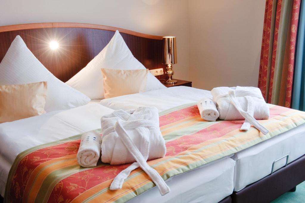 Dos toallas en una cama en una habitación de hotel en Stadthotel Stern, en Wismar