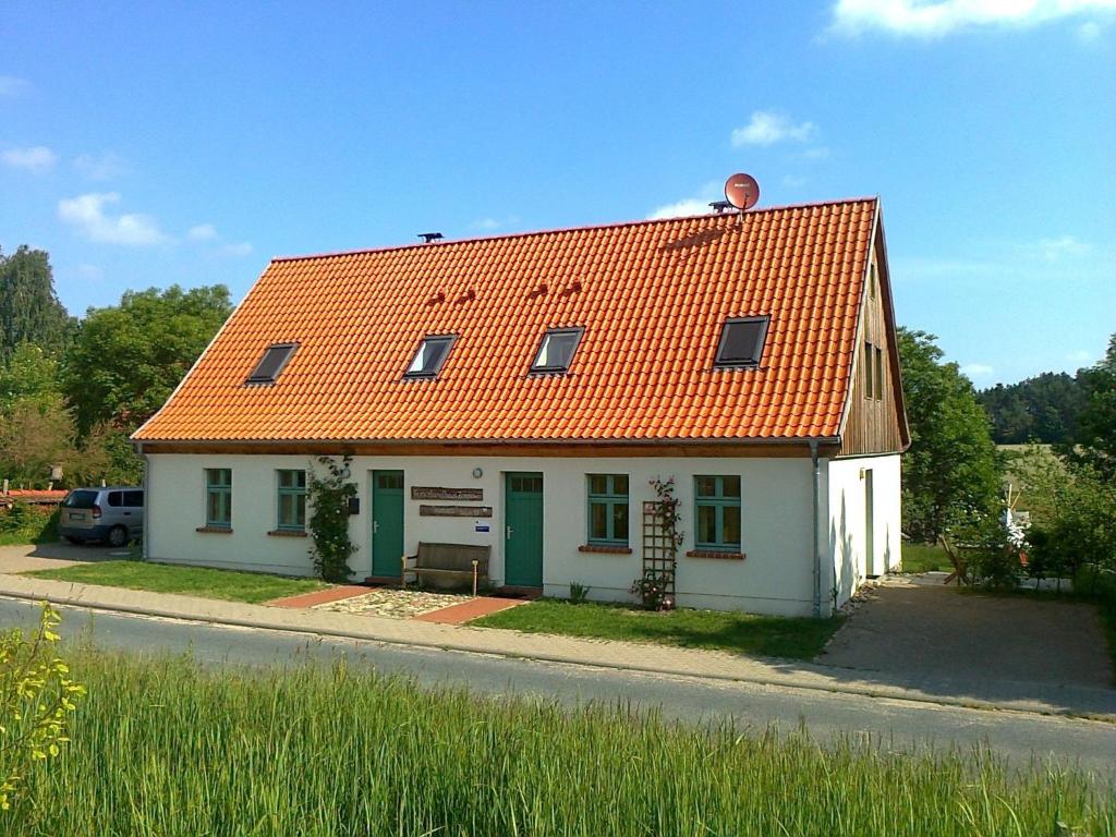 ein kleines weißes Haus mit orangefarbenem Dach in der Unterkunft Ferienlandhaus Zempow in Zempow