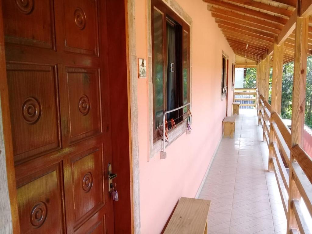 a door of a house with a porch with benches at Chalé Da Fran in Maresias