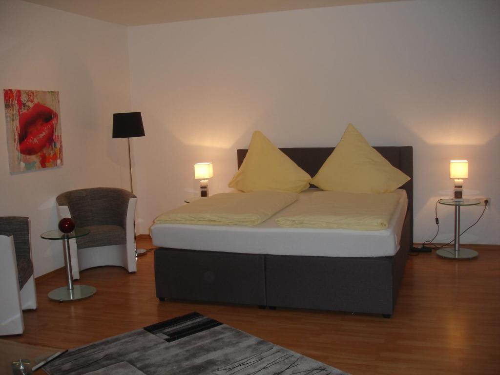 ein Schlafzimmer mit einem Bett mit vier Kissen darauf in der Unterkunft City-Pension-Dortmund in Dortmund