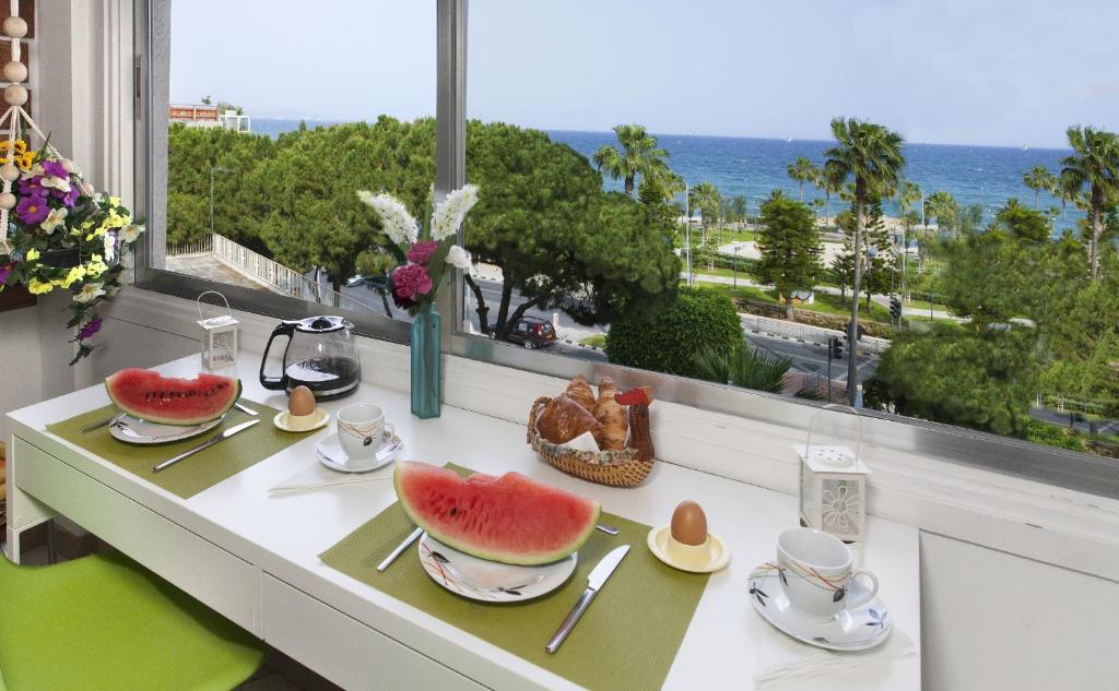 a table with fruit on it with a view of the ocean at Artemis Boutique Apartment 1 in Limassol