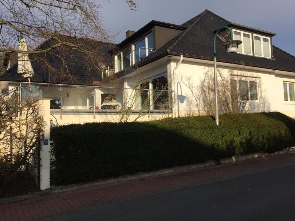 a white house with a hedge in front of it at Linas Wohlfühloase Hameln in Hessisch Oldendorf