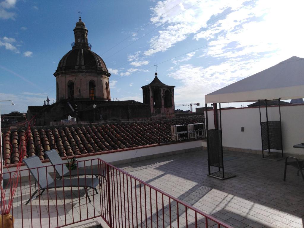 una azotea de un edificio con una iglesia en el fondo en Manzoni Suite Home, en Catania