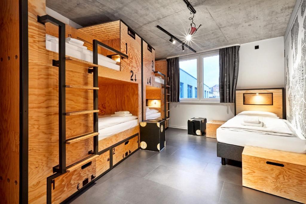 a room with two beds and a bunk bed at H.ostel Münster in Münster