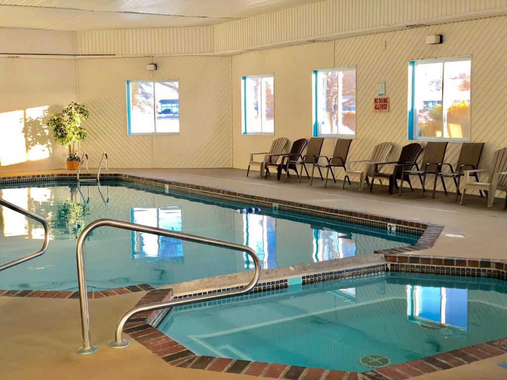 a large swimming pool with chairs in a building at Super 8 by Wyndham Escanaba in Escanaba