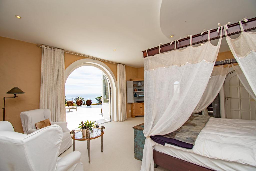 a bedroom with a canopy bed and a window at Four Uitsig Camps Bay in Cape Town