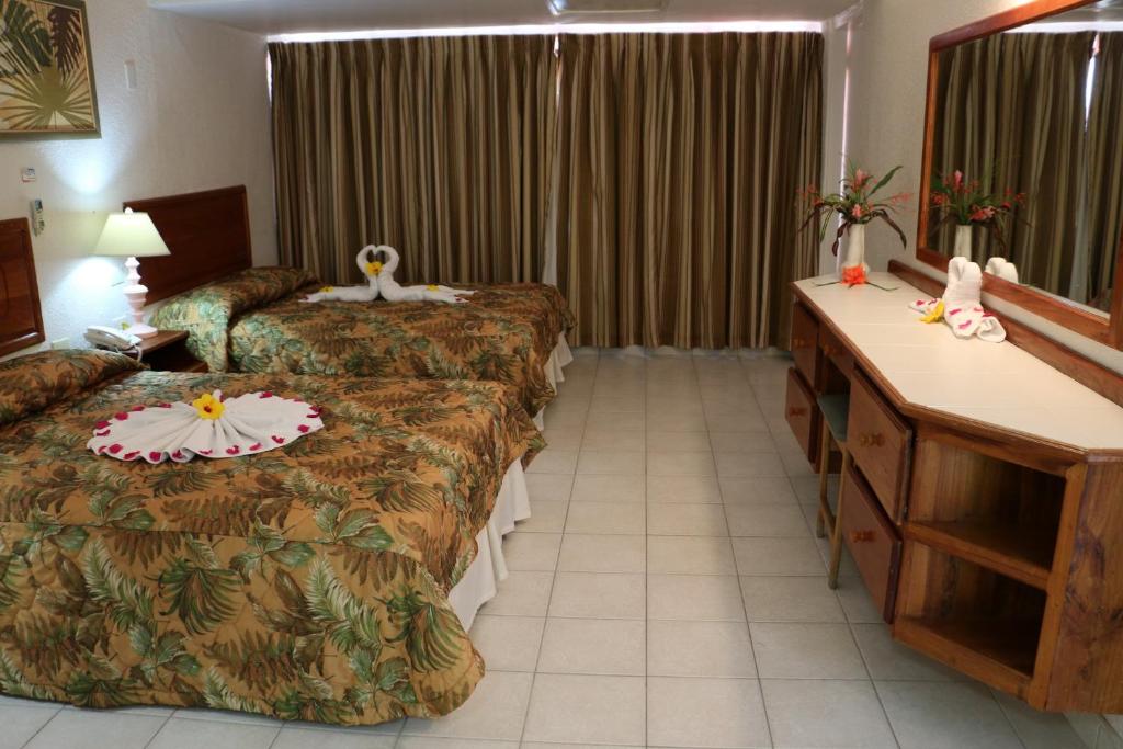 a hotel room with two beds and a desk at Crown Point Beach Hotel in Crown Point