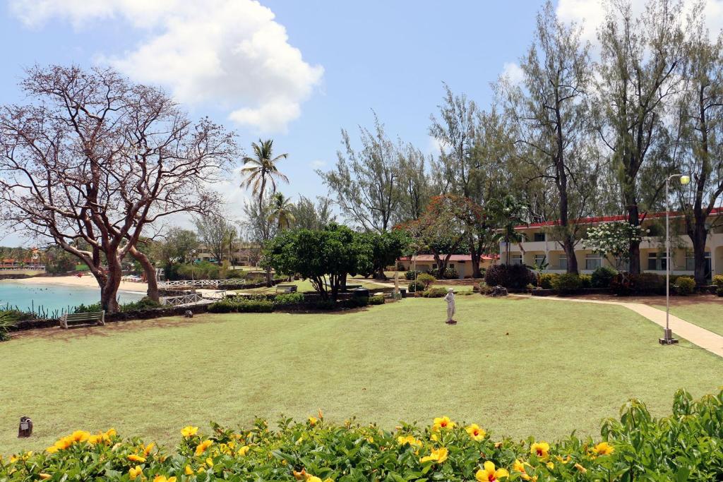 a park in front of a building next to a body of water at Crown Point Beach Hotel in Crown Point