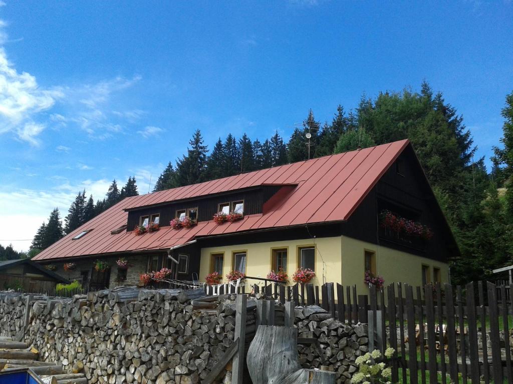 una casa con techo rojo y valla en Pension Arnika en Modrava