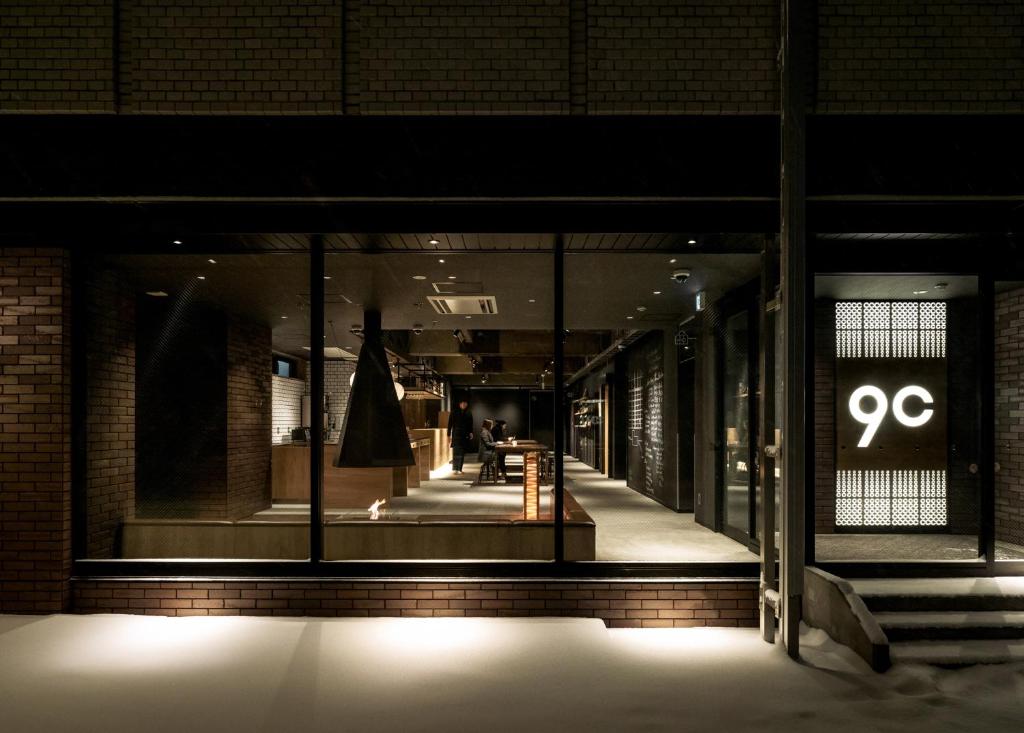 a store front at night with a sign in the window at 9 C Hotel Asahikawa in Asahikawa