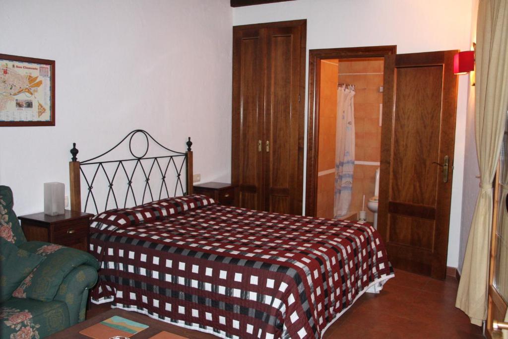 een slaapkamer met een bed met een bruine en witte deken bij Hostal Nuevo Milán I in San Clemente