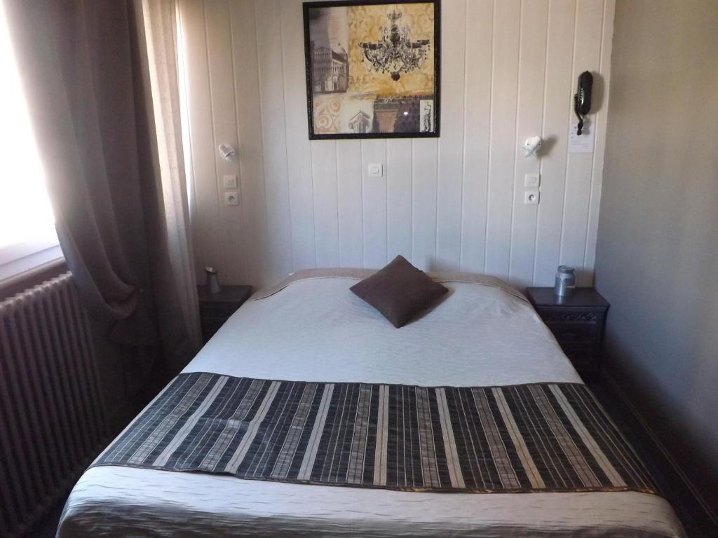 a small bedroom with a bed with a pillow on it at Hôtel De Londres in Boulogne-sur-Mer