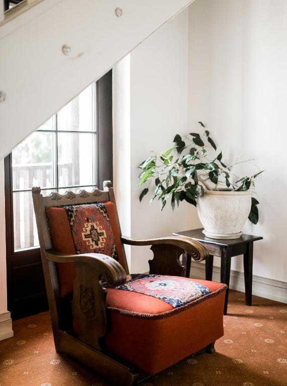 a chair and a potted plant in a room at Hotel Usadba in Kaliningrad