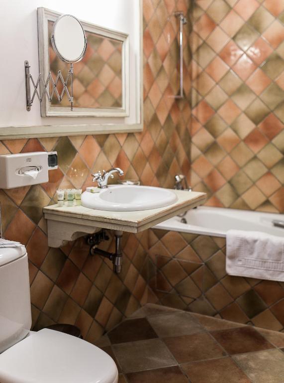 a bathroom with a sink and a toilet and a mirror at Hotel Usadba in Kaliningrad