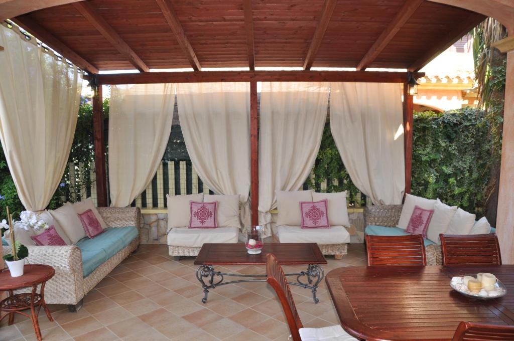 um alpendre com sofás e uma mesa em Villa Eva Luxury Villasimius em Villasimius