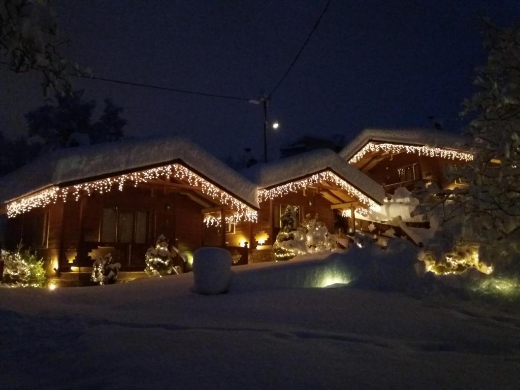 a house covered in christmas lights in the snow at 4epoxesxenonas in Synikia Mesi Trikalon