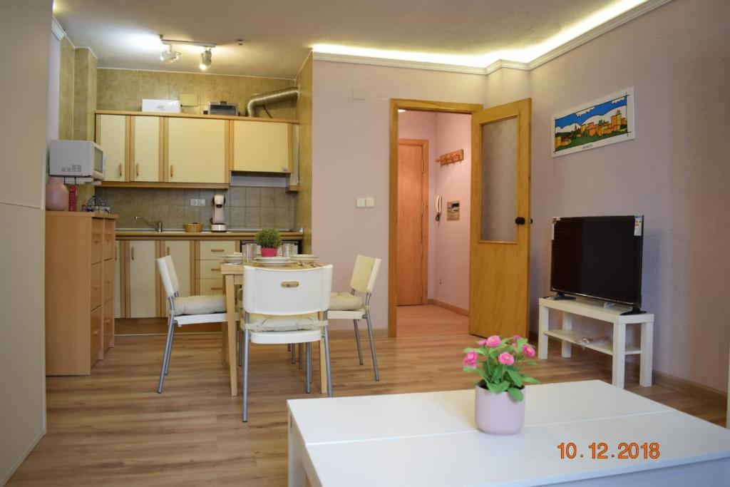 ein Wohnzimmer mit einer Küche sowie einem Tisch und Stühlen in der Unterkunft SUEÑO NEVADO MONT BLANC plaza PRADOLLANO in Sierra Nevada