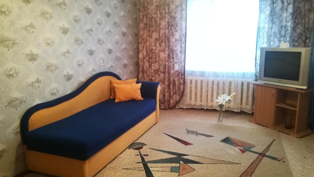 a living room with a bed and a television at Квартира на ул. Ленина 42 in Salihorsk