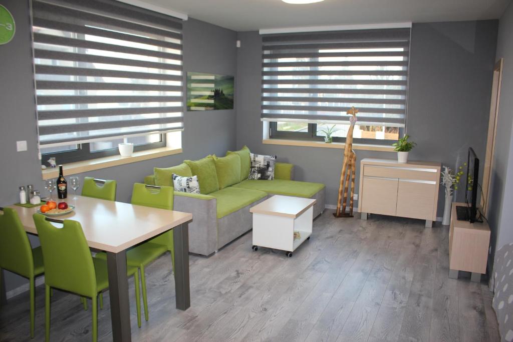 - un salon avec un canapé vert et une table dans l'établissement Apartments Severka, à Prague