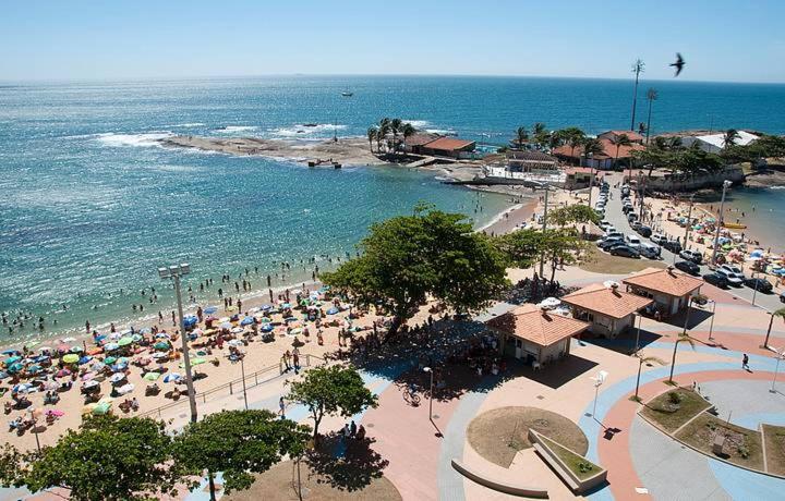 a beach with a crowd of people and the ocean at Confortável 2 Quartos Castanheiras in Guarapari