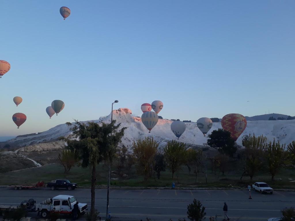 un groupe de montgolfières survolant une montagne dans l'établissement Alida Hotel, à Pamukkale