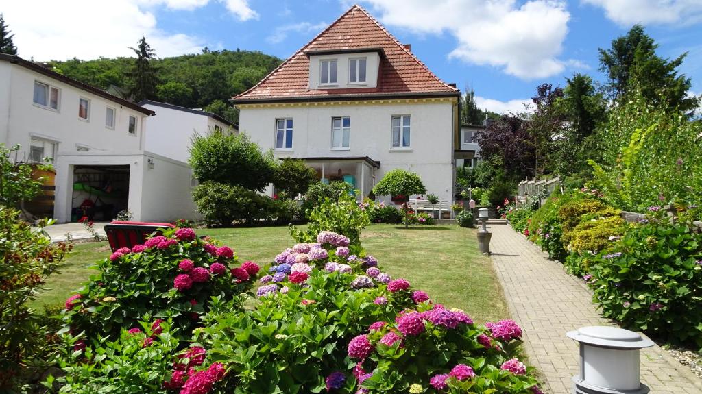 ein Haus mit einem Garten mit Blumen davor in der Unterkunft Ferienwohnung Loma in Bad Harzburg