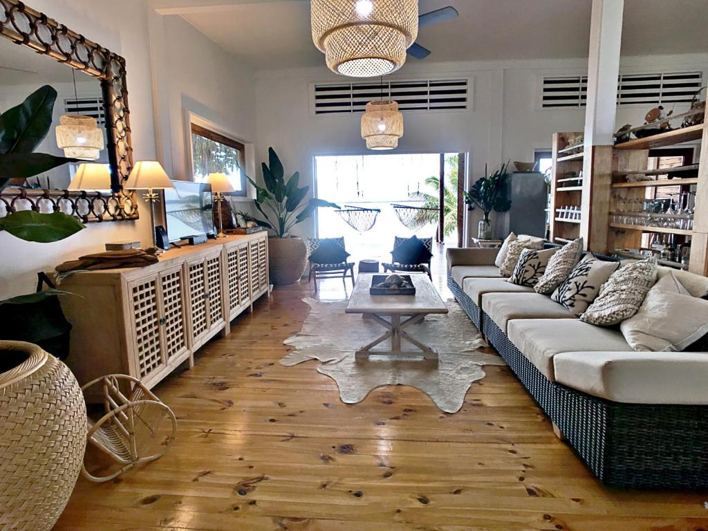 uma sala de estar com um sofá e uma mesa em Sails Beach House em Luganville