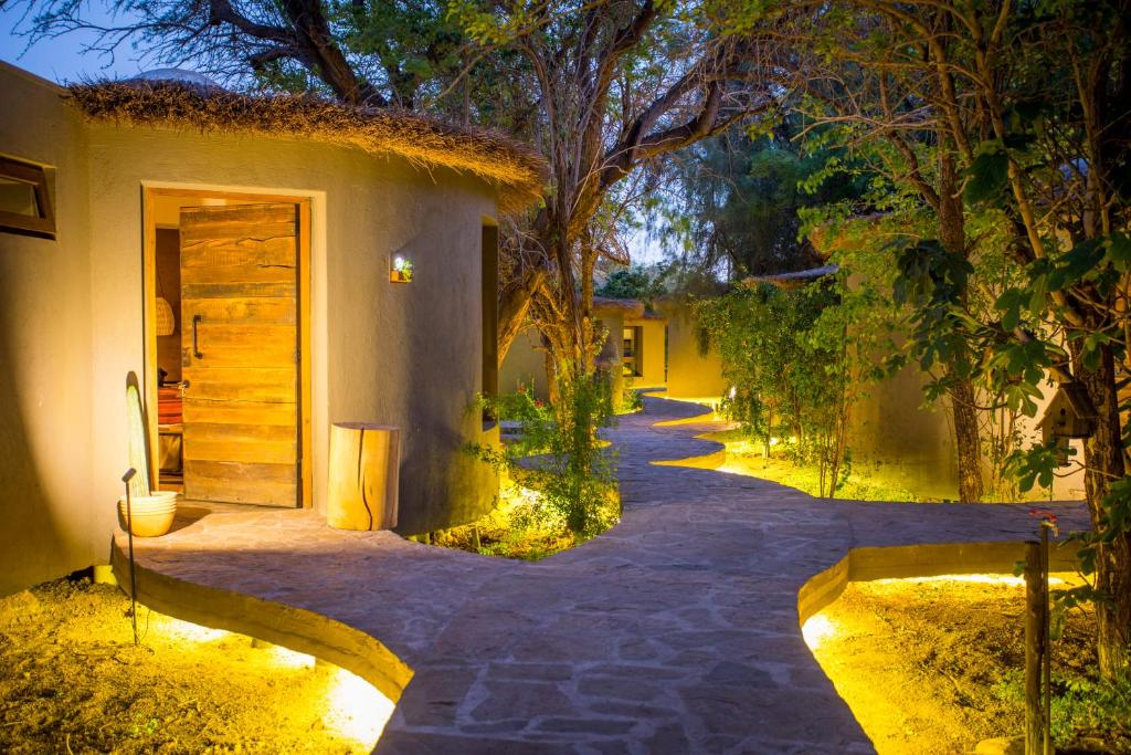 a walkway leading to a forest filled with trees at Hotel Desertica in San Pedro de Atacama