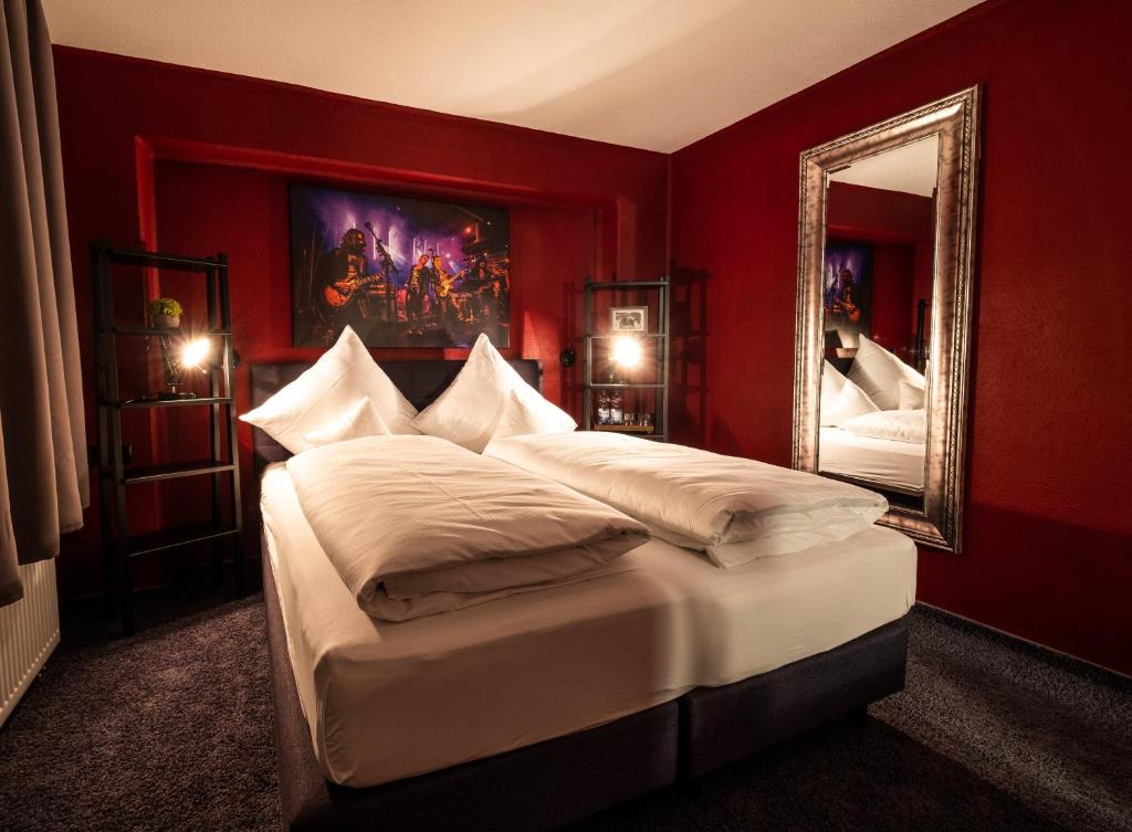 a bedroom with a large bed and a mirror at Engel Hotel + Diner in Aulendorf