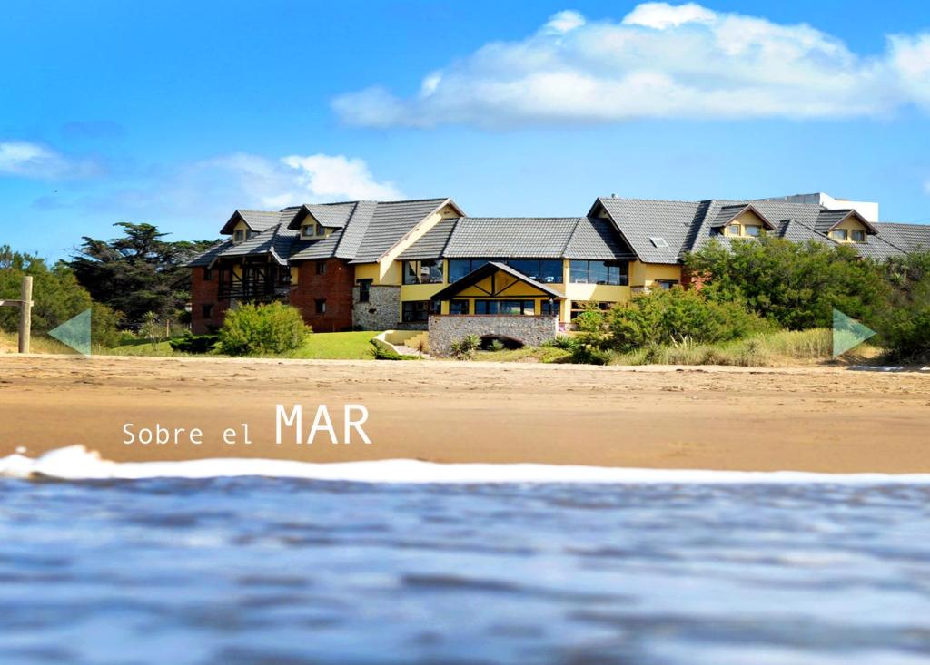 a house on the beach near the ocean at Hotel Boutique Arenarena in Villa Gesell