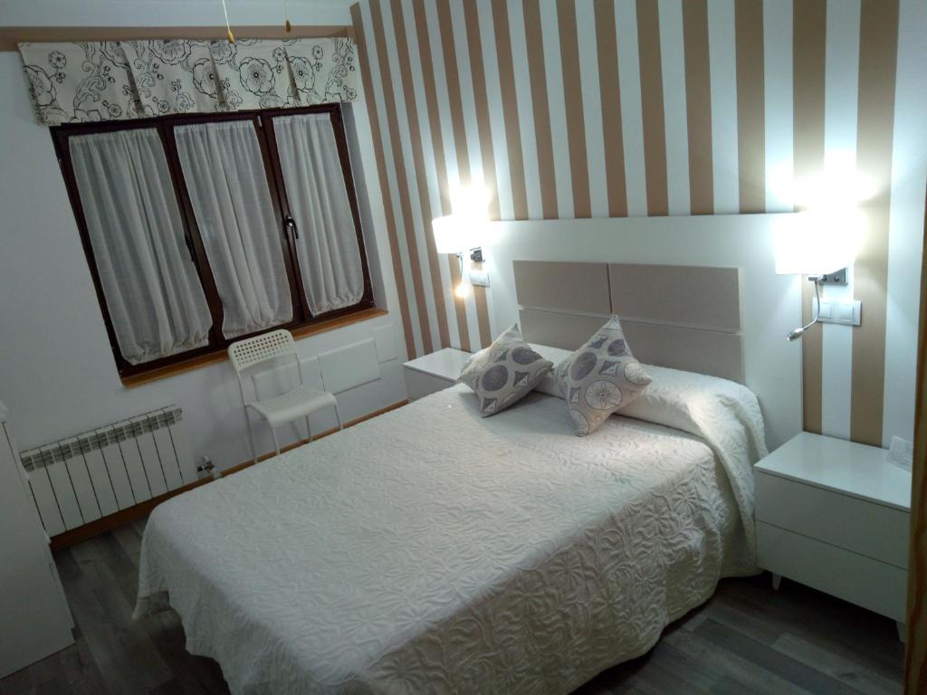 a hotel room with a bed and two lamps at Don Diego in Ávila