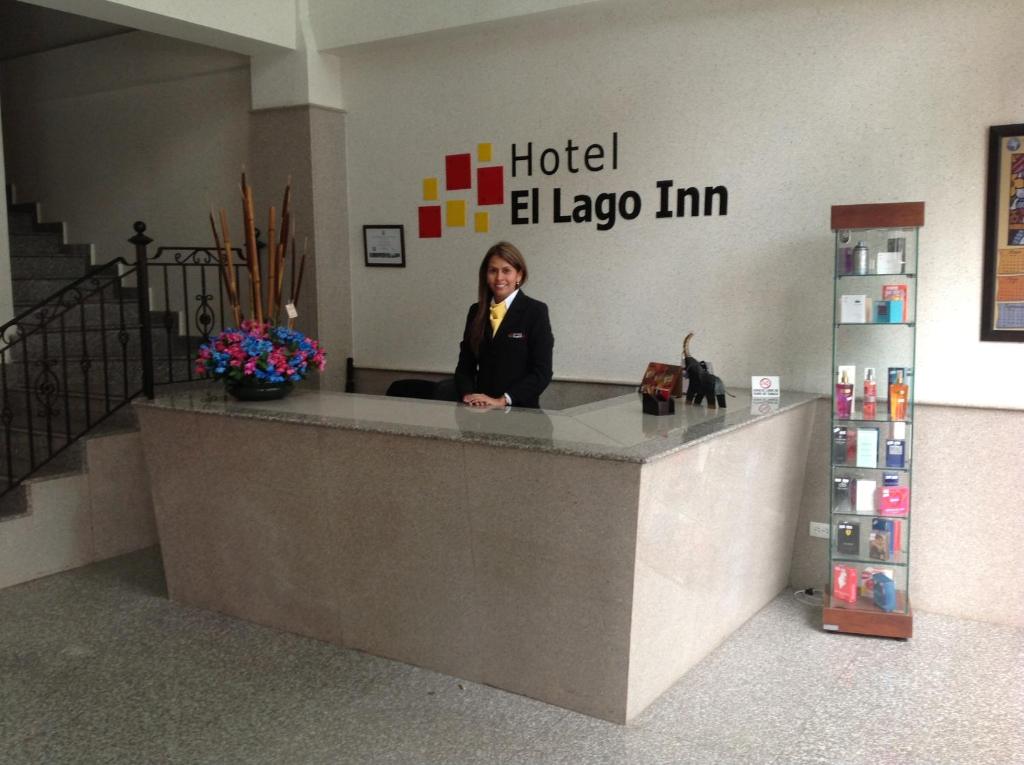 a woman sitting at a hotel elleeim counter at Hoteles Bogotá Inn El Lago Country in Bogotá