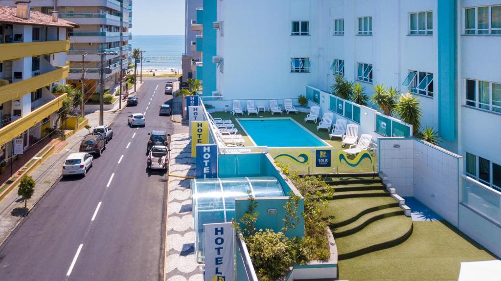 - une vue aérienne sur un bâtiment avec une piscine et une rue dans l'établissement Solis Praia Hotel Itapema, à Itapema