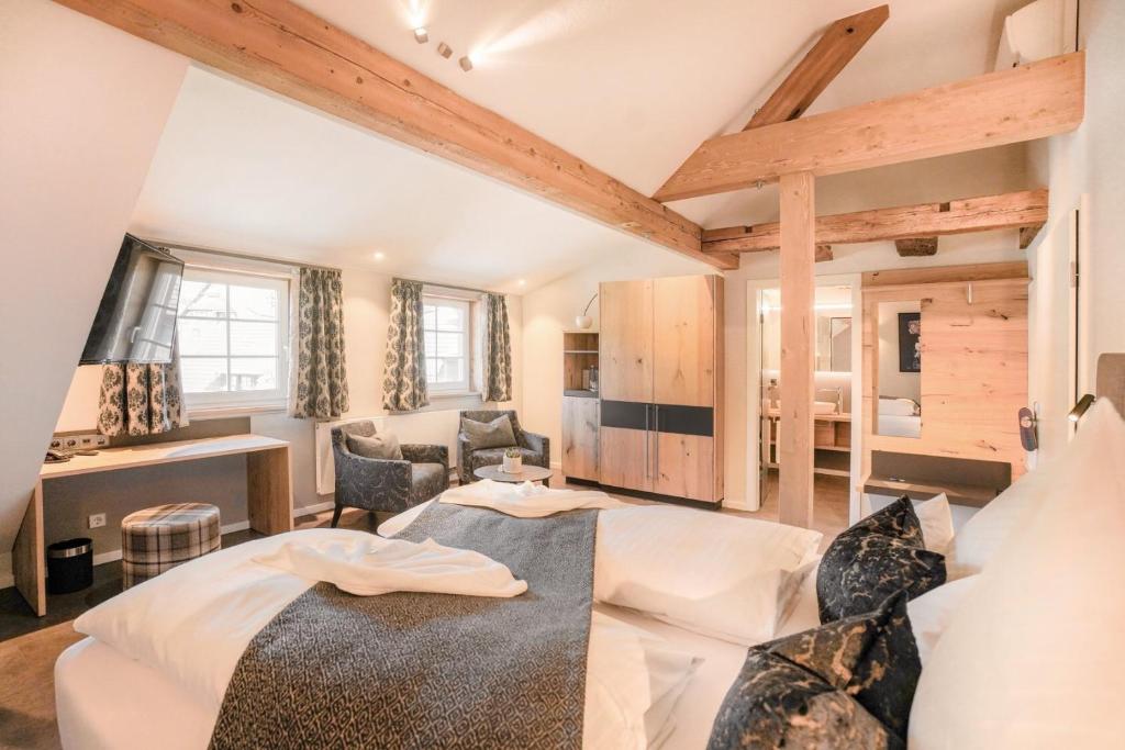 ein Schlafzimmer mit einem Bett und ein Wohnzimmer in der Unterkunft Hotel Restaurant Der Engel, Sasbachwalden in Sasbachwalden