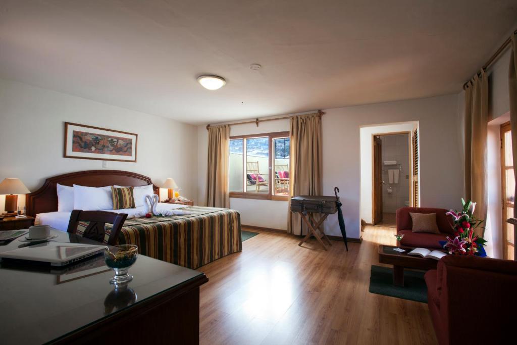 a hotel room with a bed and a table at San Agustin Internacional in Cusco