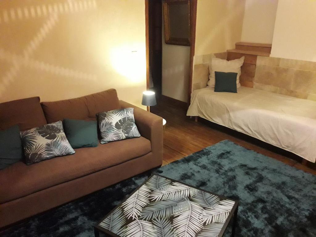 a living room with a couch and a bed at Chambres d'hôtes Belle Occitane in Tarascon-sur-Ariège