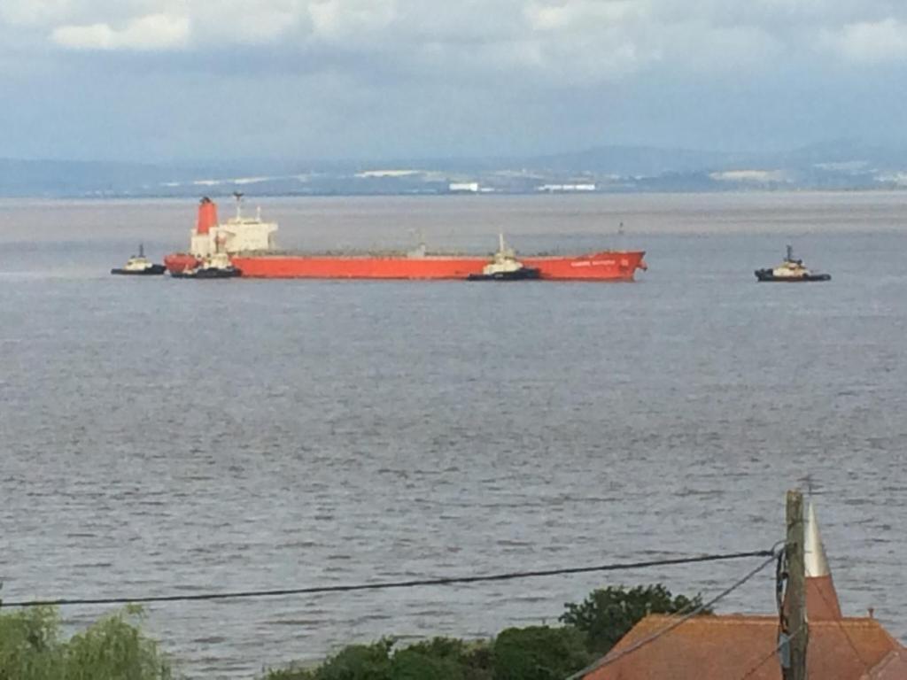 a large red container ship in the water at The Nook @ Drop Anchor in Portishead