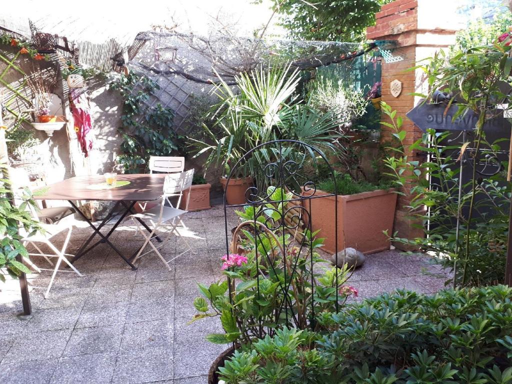 a small garden with a table and some plants at Chambres d'hôtes Belle Occitane in Tarascon-sur-Ariège