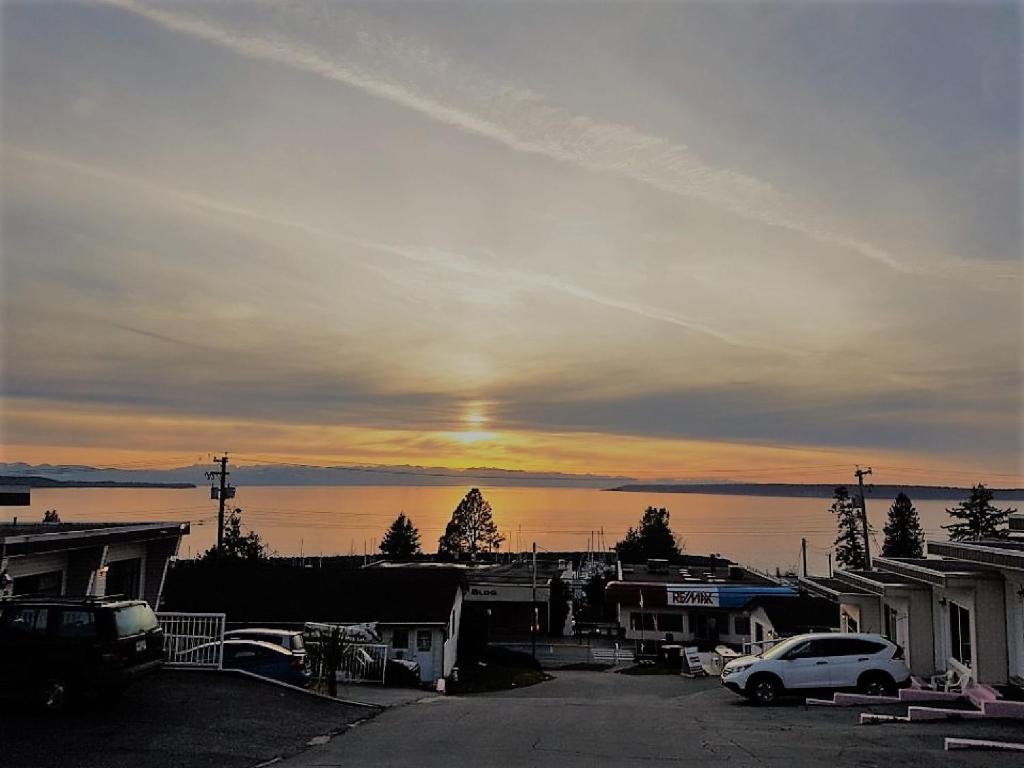 a sunset over a town with cars parked on a street at Westview Centre Motel in Powell River