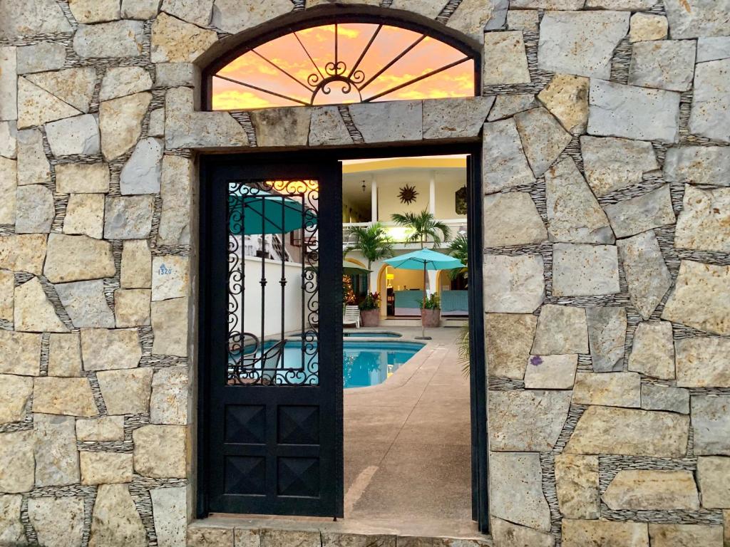 a door in a stone building with a pool at Hotel Cosmos in Tamasopo