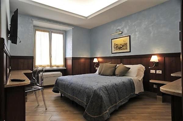 a bedroom with a bed and a desk and a window at Residenza Matteucci in Rome