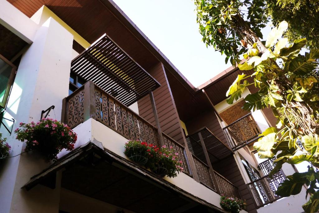 a building with potted plants on the balcony at Mountain View GuesthouseChiangmai in Chiang Mai