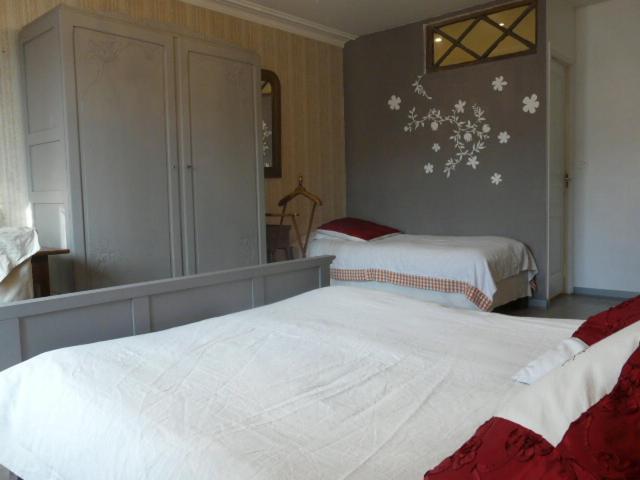 a bedroom with two beds and a mirror at Topaze in Monnières