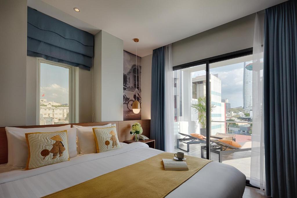 a bedroom with a large bed and a large window at Little Saigon Boutique Hotel in Ho Chi Minh City